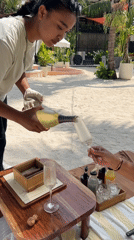 Champagne and wine poured on a sandy Bali beach
