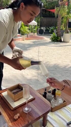 Champagne and wine poured on a sandy Bali beach