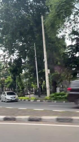Vehicle footage captures Jakarta street scene with cathedral structure