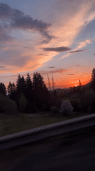 Driver captures vibrant sunset while traveling through Russian village