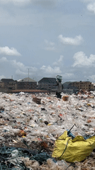 Urban contrasts: landfill worker and market mannequins captured simultaneously