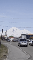 Urban street scene documented against snowy mountain backdrop