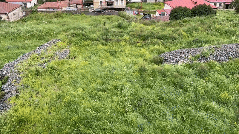Stepantsminda valley and Gergeti Trinity Church under overcast skies