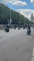 Motorcycle parade travels in formation on multi-lane road