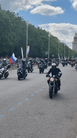 Motorcycle parade travels in formation on multi-lane road