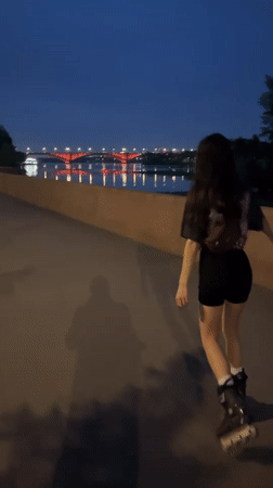 Evening rollerblading session observed along illuminated Krasnoyarsk waterfront boardwalk