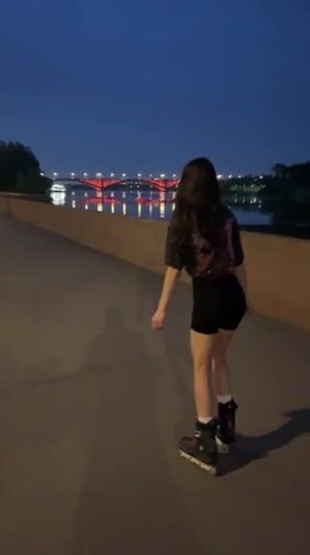 Evening rollerblading session observed along illuminated Krasnoyarsk waterfront boardwalk