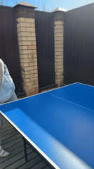 Woman plays ping pong in Chaikovsky backyard setting
