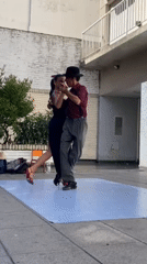 Couple performs tango on sidewalk dance floor in Buenos Aires