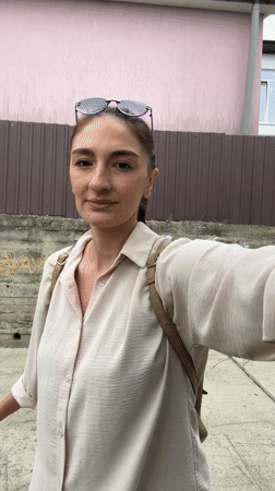 Woman with baby stroller navigates Sochi streets during afternoon outing