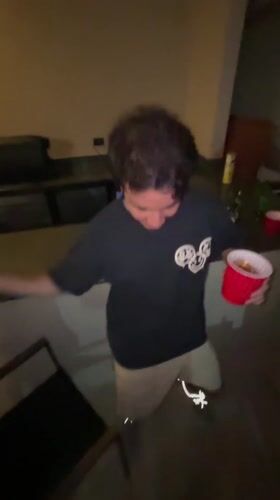 Young man dances with cup and cigarette in Mexico