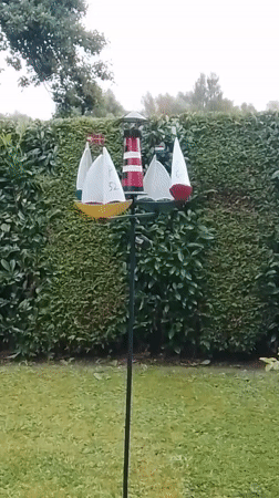 Nautical garden decor: spinning lighthouse whirligig and seashells in Wedel