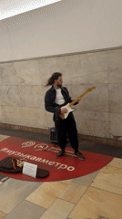 Street musician performs electric guitar in Moscow metro station