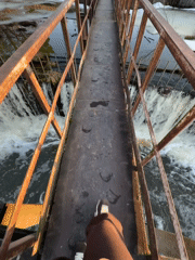 Woman explores rusty dam bridge in Rusalevka, Russia