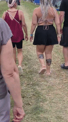 Tents, a parked motorcycle, and foot traffic at a Russian outdoor gathering