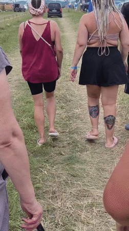 Tents, a parked motorcycle, and foot traffic at a Russian outdoor gathering