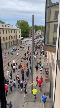Marathon runners of varied ages race through Riga streets