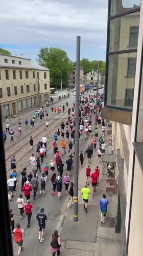 Marathon runners of varied ages race through Riga streets