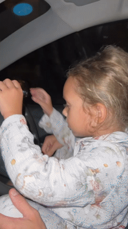 Child in pajamas sits behind wheel in Thailand