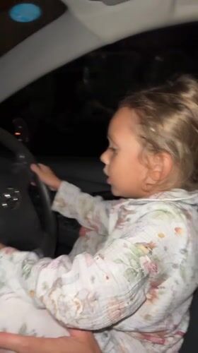 Child in pajamas sits behind wheel in Thailand