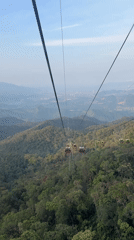 Cable car passengers travel through forested mountains near Đà Nẵng