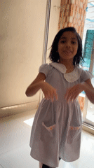 Young girl dances joyfully in Dhaka hallway