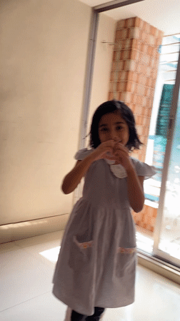 Young girl dances joyfully in Dhaka hallway