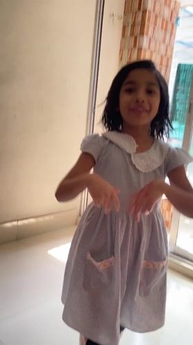 Young girl dances joyfully in Dhaka hallway