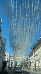 Car passes under decorative street canopy in city