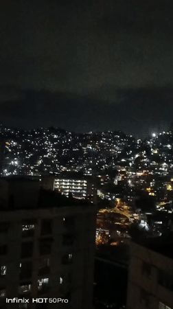 Nighttime Caracas captured from above, children play indoors