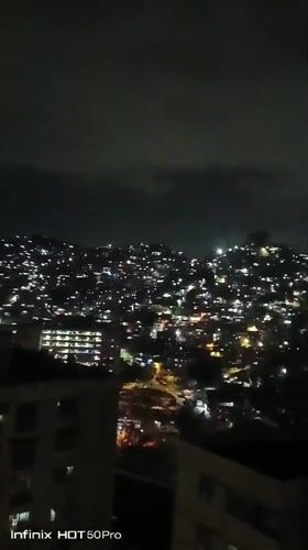 Nighttime Caracas captured from above, children play indoors