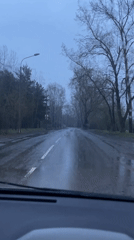 Car drives wet road during cloudy evening in Krasnoyarsk