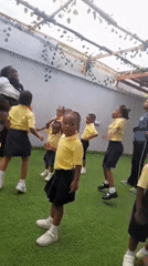 Preschoolers in yellow uniforms participate in morning dance activity