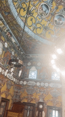 Ornate mosque interior with vivid murals and painted ceiling