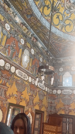 Ornate mosque interior with vivid murals and painted ceiling