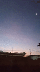 Crescent moon observed during dawn twilight over urban area