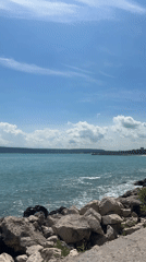 Sunny coastal day draws leisure visitors to rocky shoreline