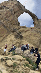 Families explore natural rock archway formation near Мирный, Russia