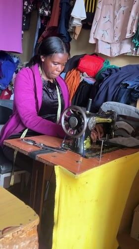 Woman operates vintage sewing machine in Nyeri tailor workshop