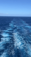 Ship creates wake pattern in blue ocean waters