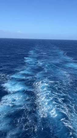 Ship creates wake pattern in blue ocean waters