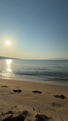 Dawn breaks over Nesebar beach as sunrise illuminates calm waters