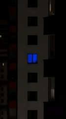 Building window displays shifting colored lights at night