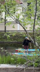 Three paddleboarders navigate narrow canal in Saint Petersburg