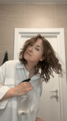 Woman uses spray bottle in Moscow bathroom setting