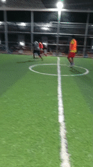 Men play indoor soccer on artificial turf field