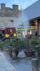 Water sprays inside London fire station with firefighters present