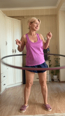 Woman hula hoops indoors in early morning Sochi