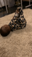 Infant plays on rug in Nigerian home