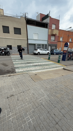 Masked scooter rider performs street tricks in Badalona